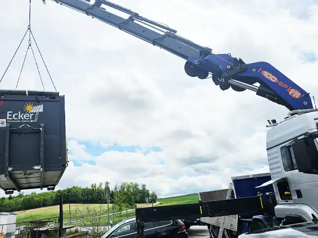 Baukran mieten: Hochleistungs-Kran hebt Container für Bauprojekte, effiziente Logistik und Baustellenmanagement.