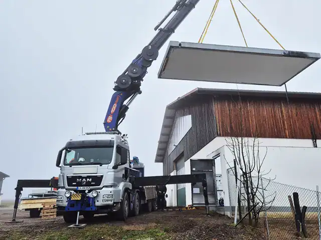 kranarbeiten-mobilkran-mit-betonplatte-am-haus